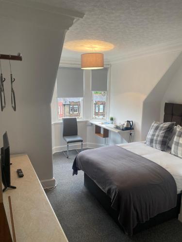 a bedroom with a bed and a desk and a chair at Ellwyn House in Edinburgh