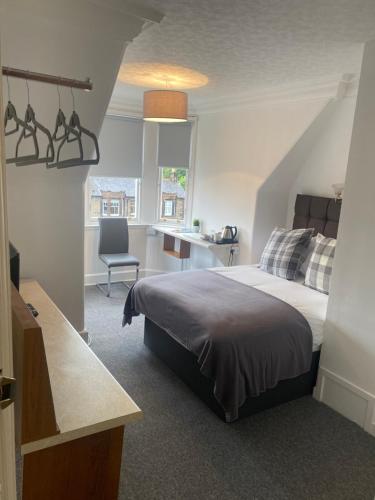 1 dormitorio con cama, escritorio y silla en Ellwyn House, en Edimburgo