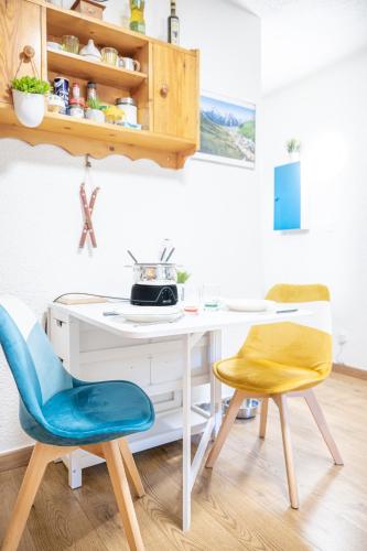 - une cuisine avec un bureau blanc et 2 chaises dans l'établissement Les 2 Alpes - PIED DES PISTES - PLEIN CENTRE DE LA STATION au calme, à Les Deux Alpes