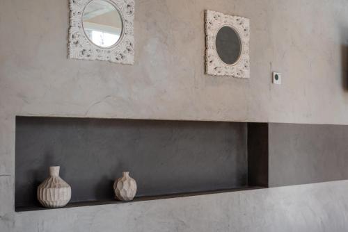 two vases sitting on a shelf with a mirror at Gran Hotel Dakar in Mendoza