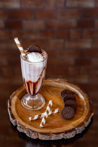 a chocolate milkshake on a wooden plate with cookies at HOTEL JS SOUVENIR in Dehradun
