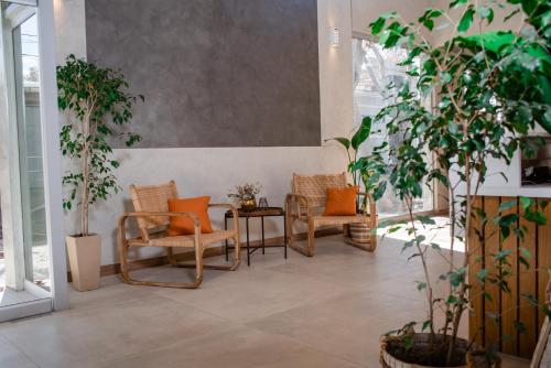 a room with chairs and a table and plants at Gran Hotel Dakar in Mendoza