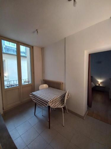 貝桑松的住宿－Le Carnot, à deux pas du centre ville，客房设有桌子、椅子和窗户。