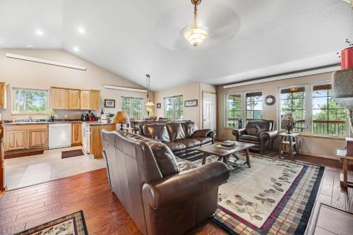 a living room with leather furniture and a kitchen at Cliffview Cabin in Nemo