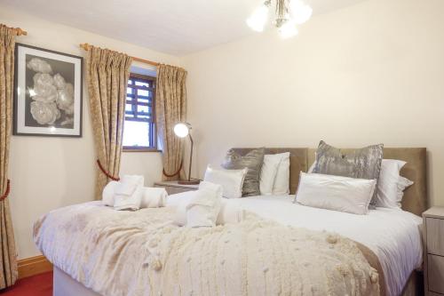 a bedroom with two large beds with white pillows at Manor House Farm 
