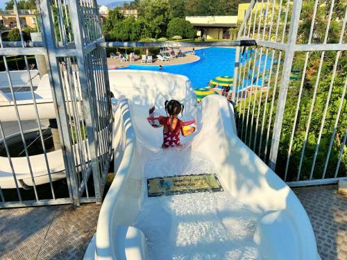 Ein kleines Mädchen auf einer Rutsche in einem Wasserpark. in der Unterkunft Pizzo Beach Club in Pizzo