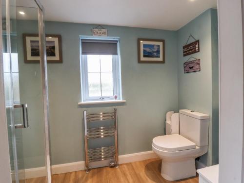 a bathroom with a toilet and a window at The Croft in Skipton