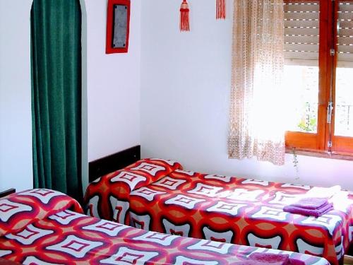 a bedroom with two beds and a window at Cal Gravat in Montsonis