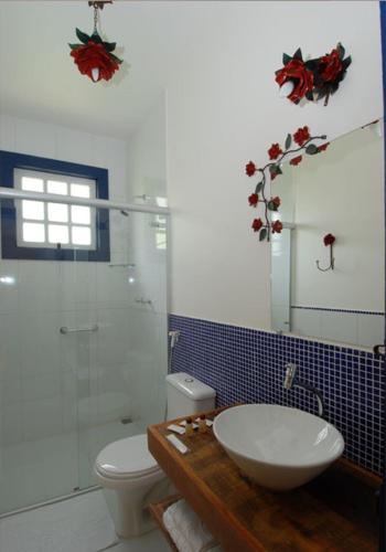 a bathroom with a sink and a toilet and a mirror at Pouso do Alferes in Santo Antônio do Leite