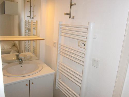 La salle de bains blanche est pourvue d'un lavabo. dans l'établissement Appartement cosy à Dévoluy avec vue sur la montagne, 26 m²., à Saint-Étienne-en-Dévoluy