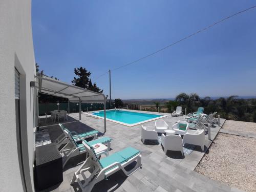 patio z krzesłami i basenem w obiekcie Villa Sara w mieście Sciacca