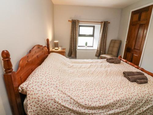 a bedroom with a bed with two towels on it at Garth Gill in Sedbergh