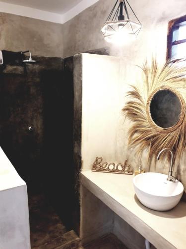 a bathroom with a sink and a mirror at Michamvi Spirit Lodge in Michamvi