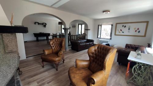 a living room with leather furniture and a piano at La Posada de la Xana in Llanuces