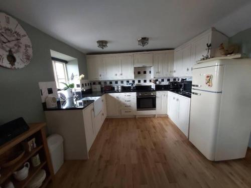 a kitchen with white cabinets and a white refrigerator at 2-Bed Apartment near Buxton Outstanding Location in Buxton