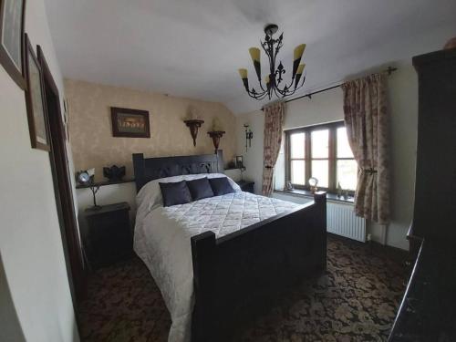 a bedroom with a large bed and a chandelier at 2-Bed Apartment near Buxton Outstanding Location in Buxton