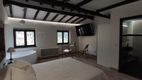 a bedroom with a bed and a tub and a sink at La Posada de la Xana in Llanuces