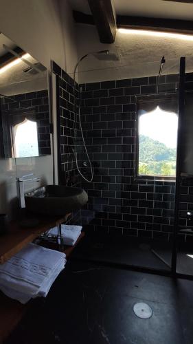 a bathroom with a sink and a brick wall at La Posada de la Xana in Llanuces