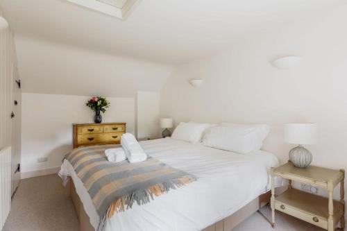 ein Schlafzimmer mit einem großen weißen Bett und einem Tisch in der Unterkunft Honeysuckle Cottage in Wareham