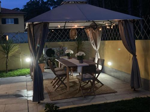 a table and chairs under an umbrella on a patio at Casa de Praia Guest House in Labruge