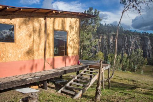 a house with a wooden porch and stairs to it at La Casa de las Estrellas in Suesca