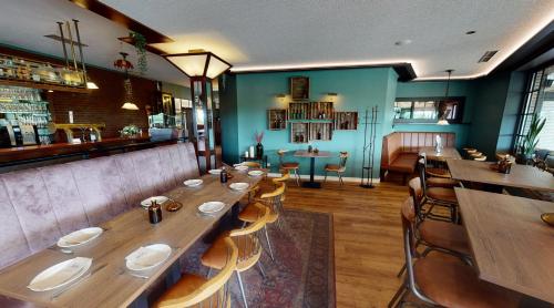 un restaurante con una larga mesa de madera y sillas en PaGa - Parkgaststaette, en Ehrenburg