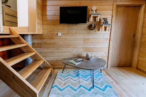 Uma TV ou centro de entretenimento em Coliving The VALLEY Portugal apartments with an office desk in each bedroom and a shared kitchen