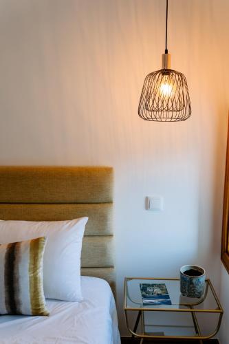 a bedroom with a bed and a table with a lamp at The VALLEY, apartamentos em casa de campo nas Montanhas Mágicas - a sala e a cozinha, localizadas numa cabana de madeira, são partilhadas in Vale de Cambra