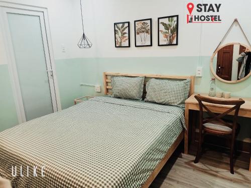 a bedroom with a bed and a desk and a mirror at STAY hostel - 300m from the ferry in Rach Gia