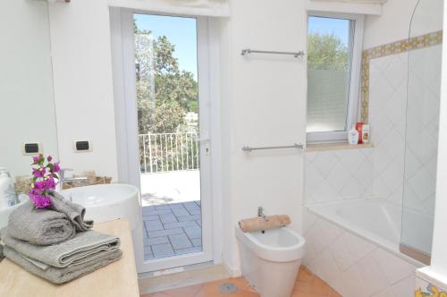 a bathroom with a tub and a toilet and a sink at CapriGetaway - Casa Due Golfi in Capri