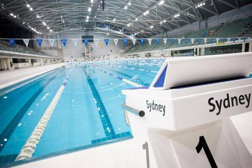 a large swimming pool in a large building at Parkside & City view in Sydney Olympic Park in Sydney