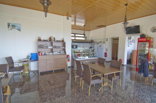 comedor con mesa, sillas y nevera en Evim Zeytinlik Pension, en Gülpınar