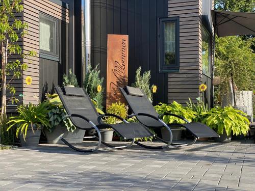 two benches sitting in front of a building at Sunset Tiny House GbR in Neuendorf