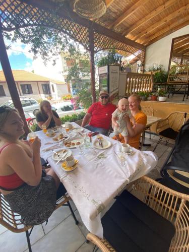 a group of people sitting around a table at a restaurant at Costas Inn in Spílion