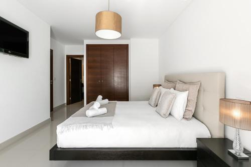 een slaapkamer met een groot wit bed met witte kussens bij Caminho da Praia in Ferrel