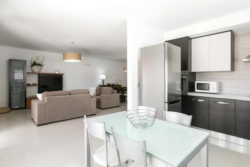 a kitchen and living room with a table and chairs at Caminho da Praia in Ferrel