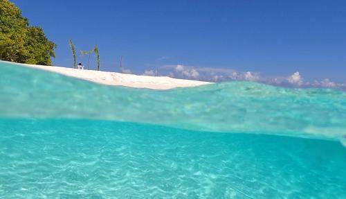 a large body of water with a beach in the background at Shamar Guesthouse & Dive in Maamigili