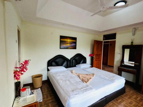 a bedroom with a large bed with a black headboard at Shamar Guesthouse & Dive in Maamigili