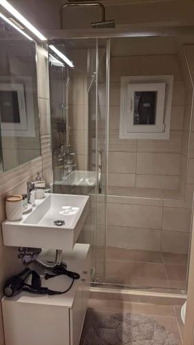 a bathroom with a sink and a shower at Elise Corfu City Apartment in Ágios Rókkos