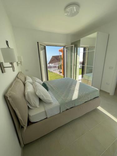 a bed in a bedroom with a large window at Villa Sofia *Luxury experience in Calabria in Zambrone