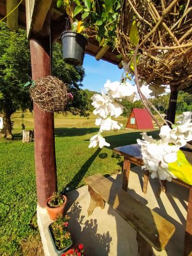 a picnic table with flowers and a bird nest at Recanto do Vale in Pomerode