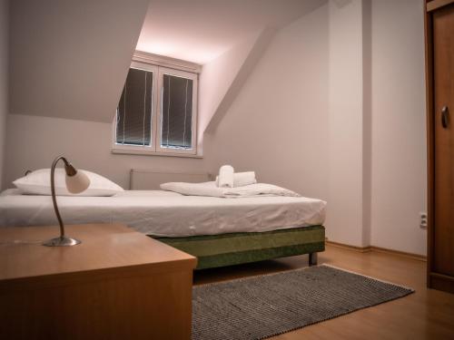 a bedroom with a bed with a lamp and a window at Hotel Novy Kastiel - Self check-in in Topoľčany