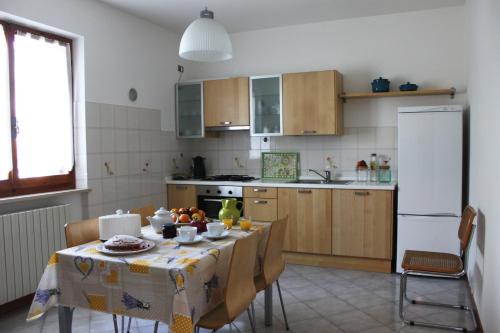 una cucina con un tavolo e un frigorifero bianco di Abbadia 14 a Osimo