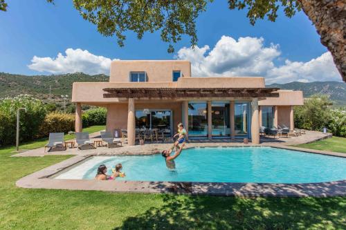 a family playing in the swimming pool of a villa at Is Molas Villas in Pula