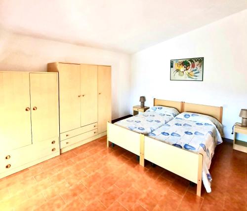 a bedroom with a bed and cabinets in it at Pineta sul mare S'Ena e Sa Chitta in Santa Lucia
