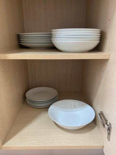 a cabinet with plates and bowls on a shelf at Appartamento Laura in Merano