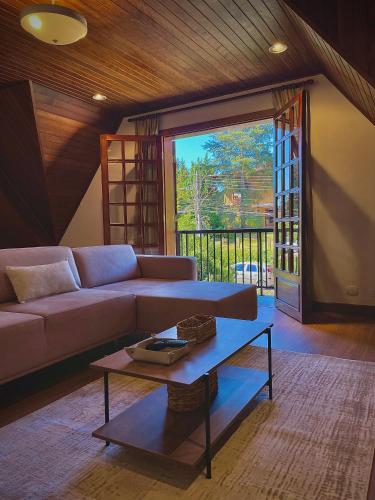 a living room with a couch and a coffee table at Casa Três Rios - Campos do Jordão in Campos do Jordão