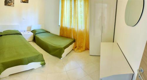 a small bedroom with two beds and a mirror at Pizzo Beach Club in Pizzo