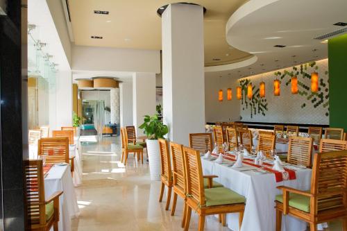 a dining room with white tables and chairs at Marival Distinct Luxury Residences & World Spa All Inclusive in Nuevo Vallarta