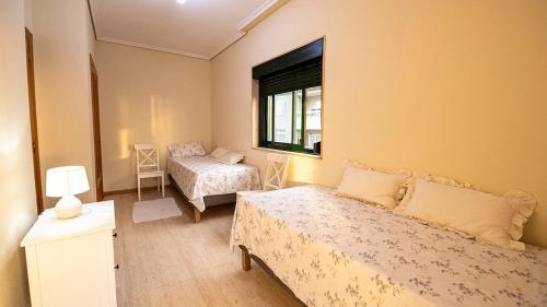 - une petite chambre avec un lit et une fenêtre dans l'établissement Apartamento playa de Samil, à Vigo